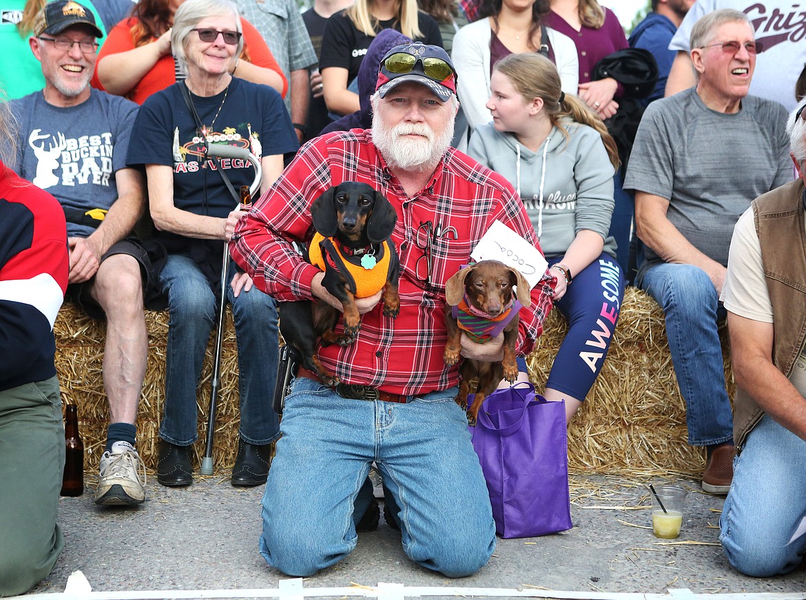 A competitor holds his two Dachsunds at the starting line.