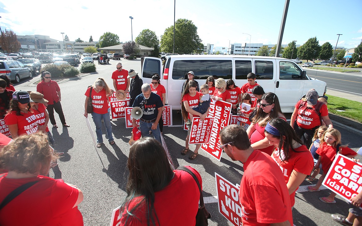 Around 25 people gather for prayer before walking over next to Kootenai Health to voice their concerns about healthcare provision for families and their children. (LOREN BENOIT/Press)