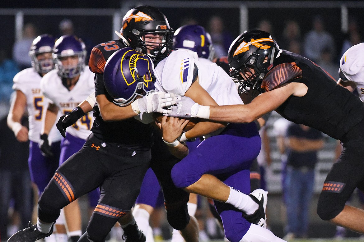 Flathead's Paxton Boyce (33) and Gatlin Bruner (6) wrap up Missoula Sentinel running back Jaxon Lee (1) on a third-quarter run at Legends Stadium on Friday. (Casey Kreider/Daily Inter Lake)