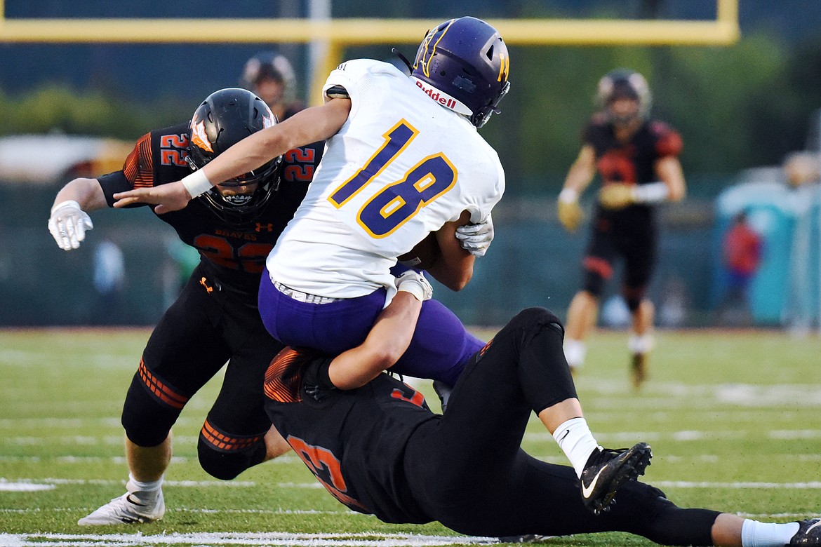 Flathead's Travis McCully (22) and Paxton Boyce (33) wrap up Missoula Sentinel quarterback Zac Crews (18) in the second quarter at Legends Stadium on Friday. (Casey Kreider/Daily Inter Lake)