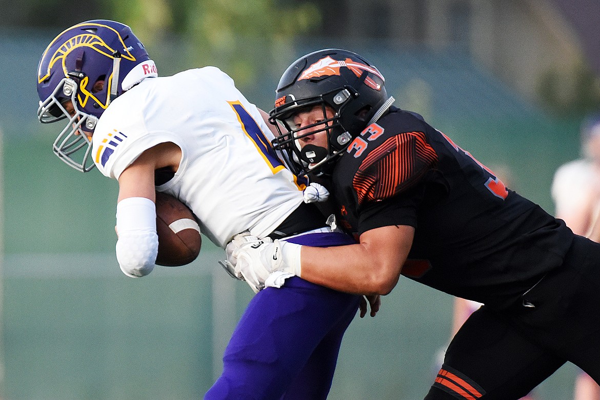 Flathead linebacker Paxton Boyce (33) sacks Missoula Sentinel quarterback Dayton Bay (4) in the first quarter at Legends Stadium on Friday. (Casey Kreider/Daily Inter Lake)