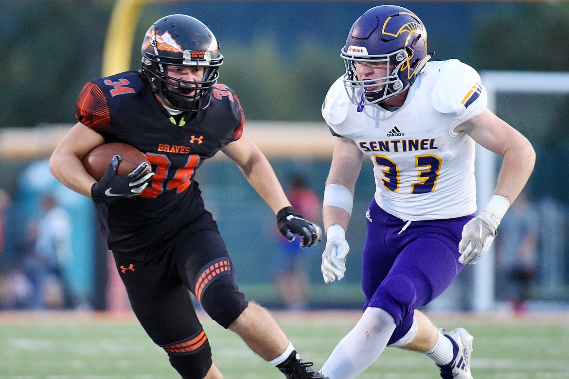 Flathead running back Drew Harrison (34) is pursued by Missoula Sentinel's Charlie Kirgan (33) on a second-quarter run at Legends Stadium on Friday. (Casey Kreider/Daily Inter Lake)