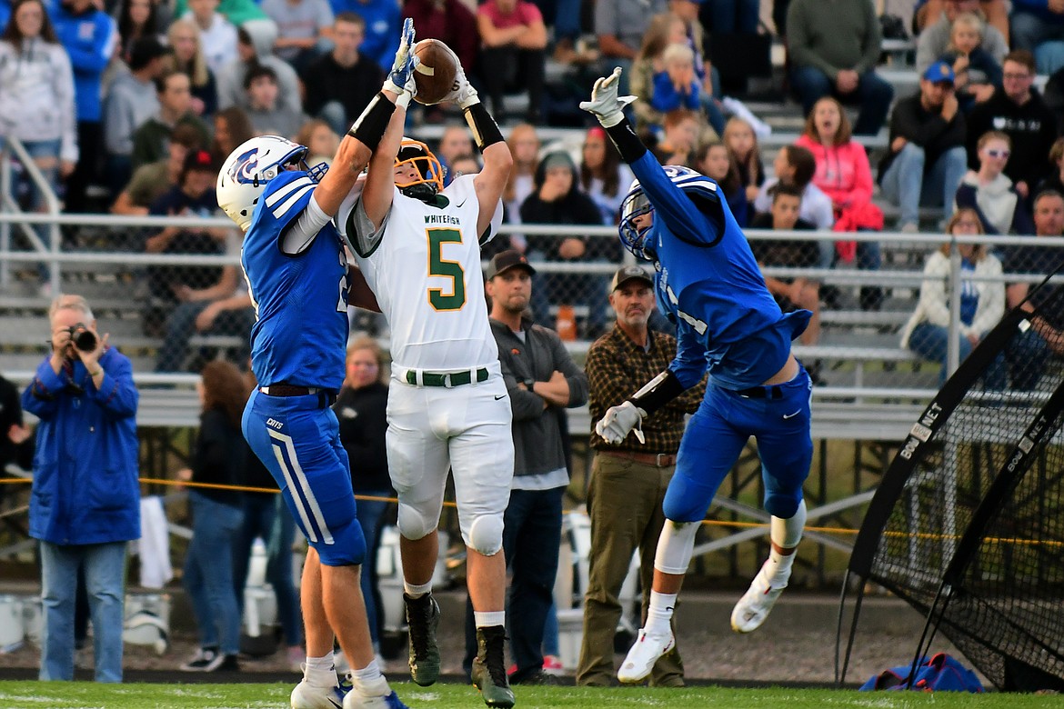 Whitefish receiver Jackson Cripe comes down with a catch against two Wildcat defenders. (Jeremy Weber/Hungry Horse News)
