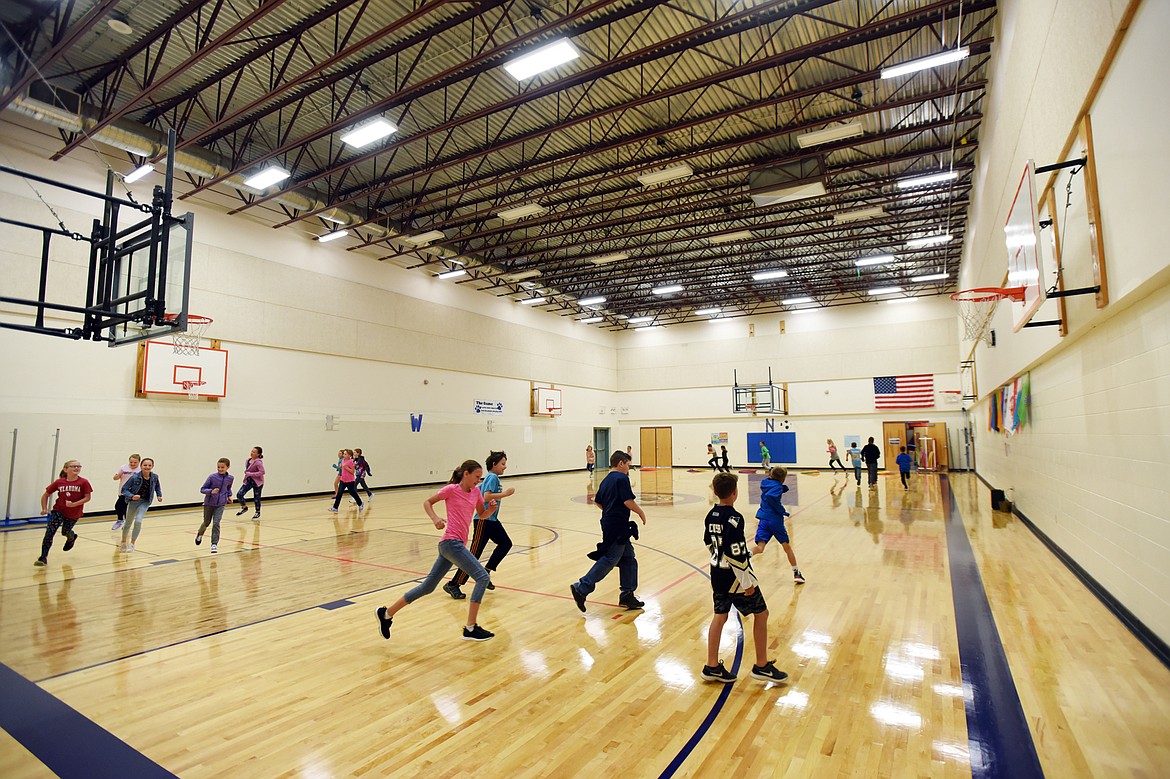 Students run laps in the gymnasium which also serves as the cafeteria at Ruder Elementary School in Columbia Falls on Wednesday, Sept. 11. (Casey Kreider/Daily Inter Lake)