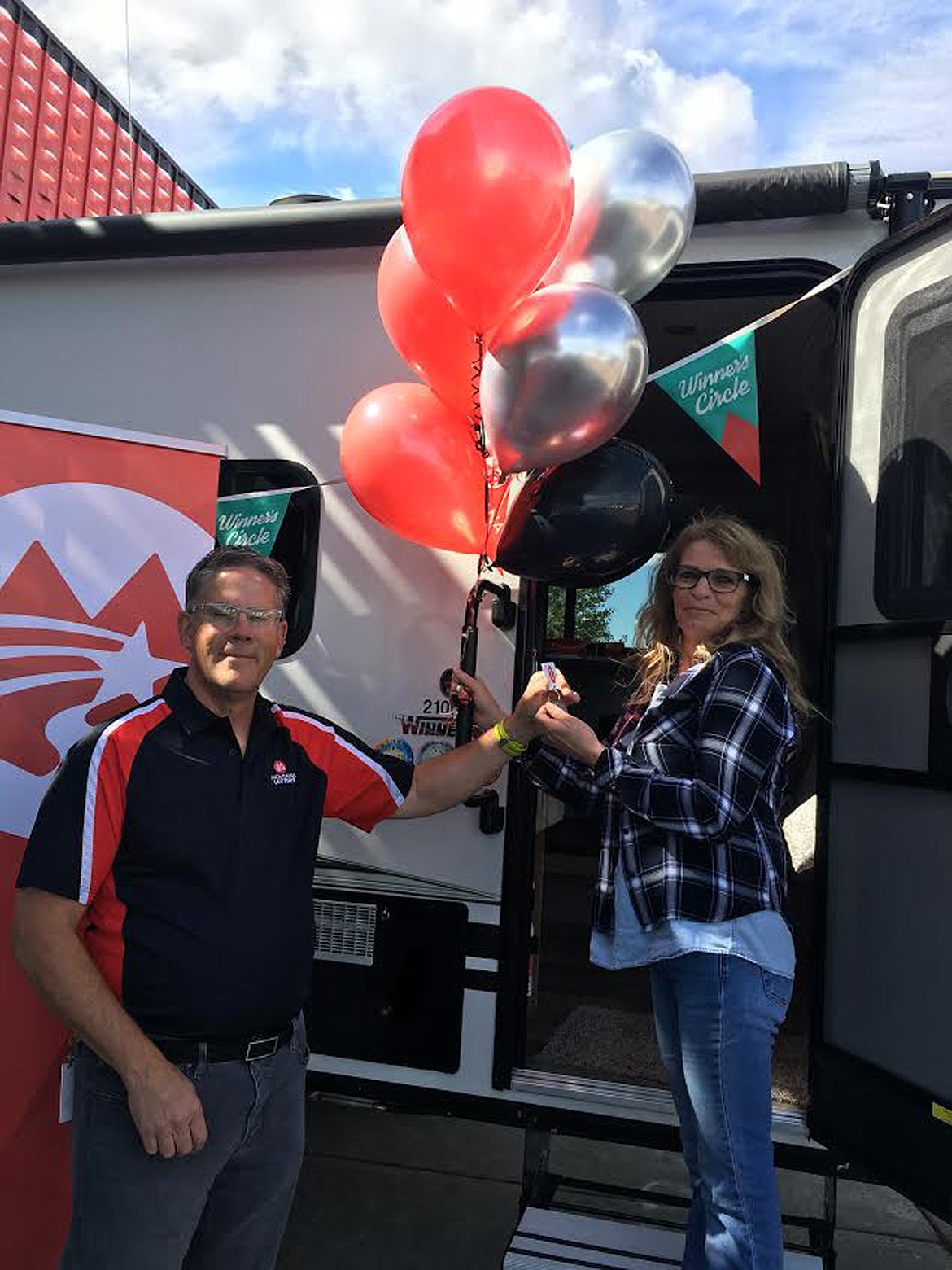 Montana Lottery scratch product manager Jay Boughn hands the key to Libby resident Sabrina Spiger Friday, Sept. 13. Spiger won a 21-foot Winnebago Micro Minnie travel trailer. (Photo courtesy Montana State Lottery)
