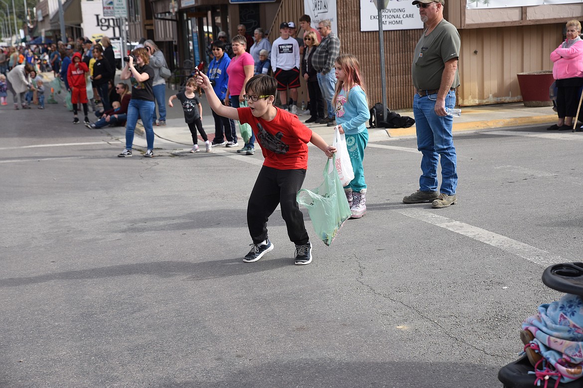 A YOUNG parade attendee grabs a piece of candy thrown by one of the many floats and service trucks that were part of Saturday&#146;s Nordicfest Parade in Libby. (Scott Shindledecker/The Western News)