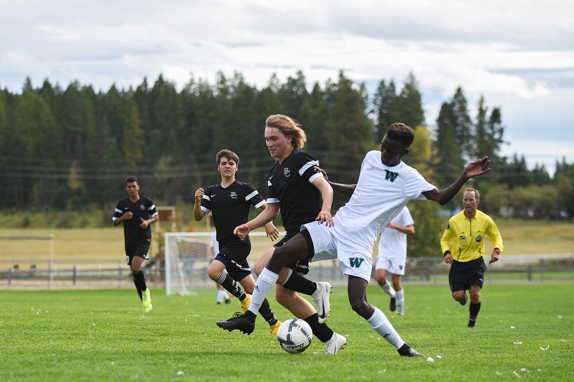 Whitefish's Marvin Kimera fights past a Billings Central defender during a home win on Saturday. (Daniel McKay/Whitefish Pilot)