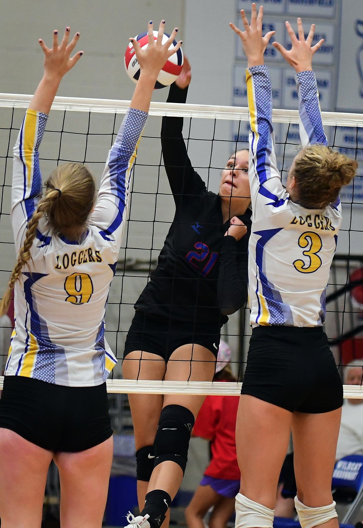 Columbia Falls outside hitter Madysen Hoerner hits the ball past Libby defenders McKenzie Proffitt (9) and Ember Rode (3) Tuesday. (Jeremy Weber/Hungry Horse News)