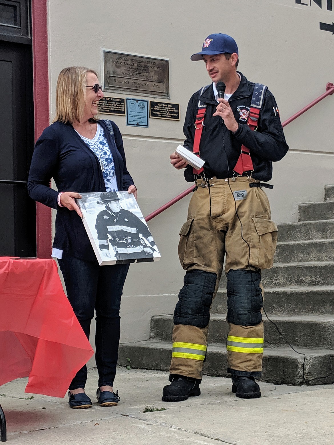 Shoshone County Fire Department No. 1 Chief Aaron Cagle presents Susan Welch, widow of former Northern Lakes Fire Chief Jeff Welch, with a professional photo of her husband and a box of chocolates. All proceeds for this year&#146;s stair climb will be donated to a memorial fund set up in honor of Chief Welch, who died in June due to lymphoma.