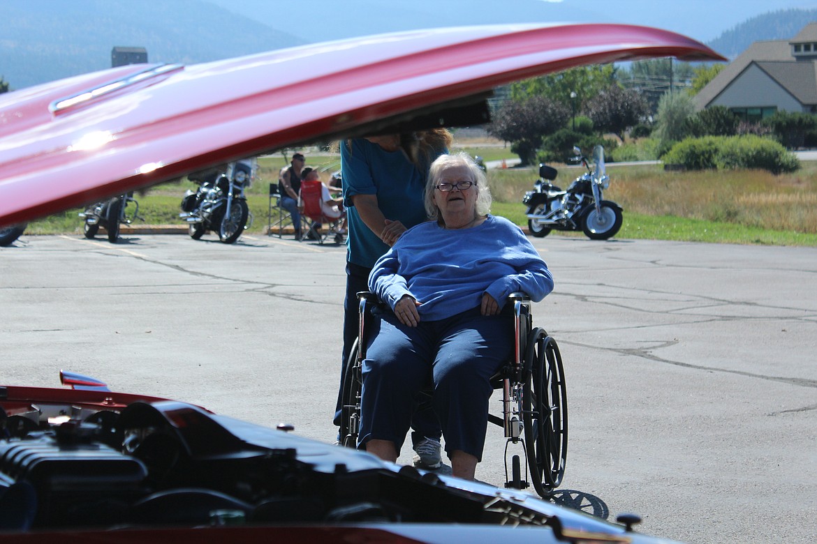 CHERYL KING, one of the long-term-care residents of Clark Fork Valley Hospital, checks out one of the vehicles in last Saturday&#146;s car show. She is being pushed in a wheelchair by Lorraine Miniat, the assistant activity director. (John Dowd/Clark Fork Valley Press)