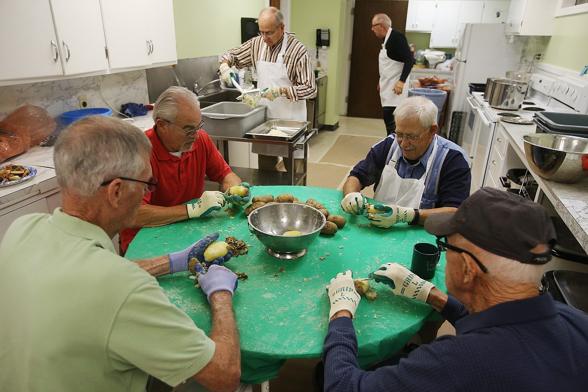 From left, Mert Barth, Ray Simmons, Richard Carlson and Ray Kincheloe peel potatoes for lefse for Trinity Lutheran Church's holiday bazaar on Nov. 2.  The leftse has to be peeled, boiled, pressed through a potato ricer and cooled before flour, sugar, salt, butter and cream go in to make dough to be grilled.  (LOREN BENOIT/Press)