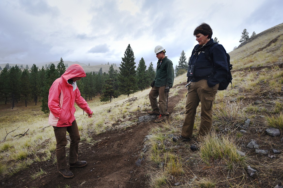 Montana Conservation Corps members Rosalie Ramirez, left, and Paul Timm, center, discuss work done to a social trail with Amy Grout, park management specialist with FWP, on Wild Horse Island State Park on Thursday, Sept. 19. (Casey Kreider/Daily Inter Lake)