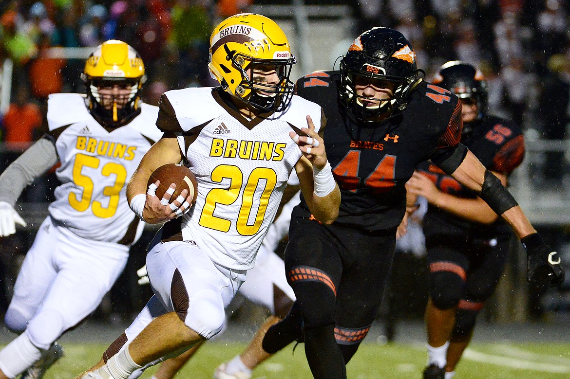 Helena Capital running back Kadyn Craigle (20) gets to the outside past Flathead defensive lineman Tanner Russell (44) in the first quarter at Legends Stadium on Friday. (Casey Kreider/Daily Inter Lake)