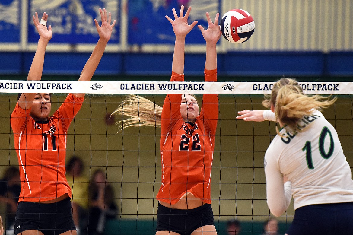 Glacier's Kynzie Mohl (10) spikes past Flathead's Kaitlyn Kalenga (11) and Julia Burden (22) during crosstown volleyball at Glacier High School on Thursday. (Casey Kreider/Daily Inter Lake)