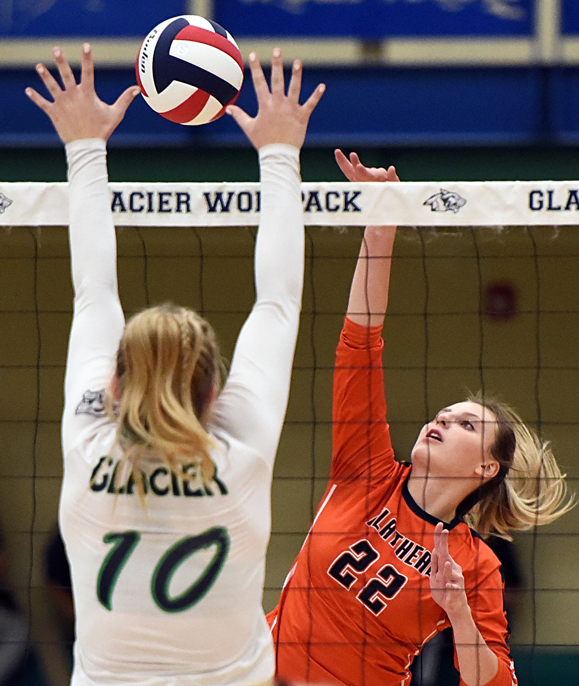 Flathead's Julia Burden (22) spikes past Glacier's Kynzie Mohl (10) during crosstown volleyball at Glacier High School on Thursday. (Casey Kreider/Daily Inter Lake)