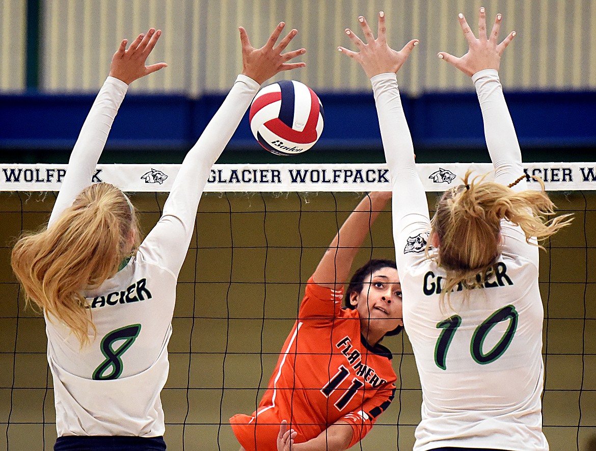 Flathead's Kaitlyn Kalenga (11) spikes past Glacier's Aubrie Rademacher (8) and Kynzie Mohl (10) during crosstown volleyball at Glacier High School on Thursday. (Casey Kreider/Daily Inter Lake)