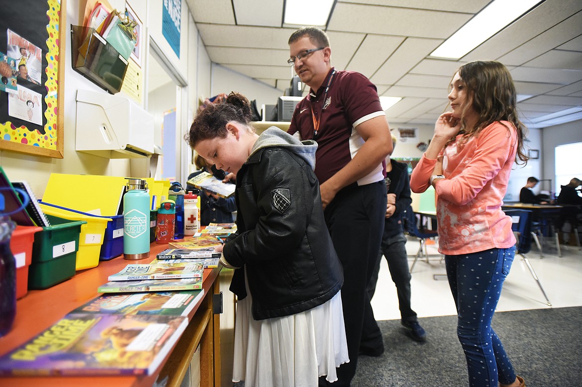 Fourth-grade teacher Josh Preiss brings out books for students to do some silent reading at Ruder Elementary School in Columbia Falls on Sept. 11. Preiss has built up his classroom library through online crowdfunding. (Casey Kreider/Daily Inter Lake)