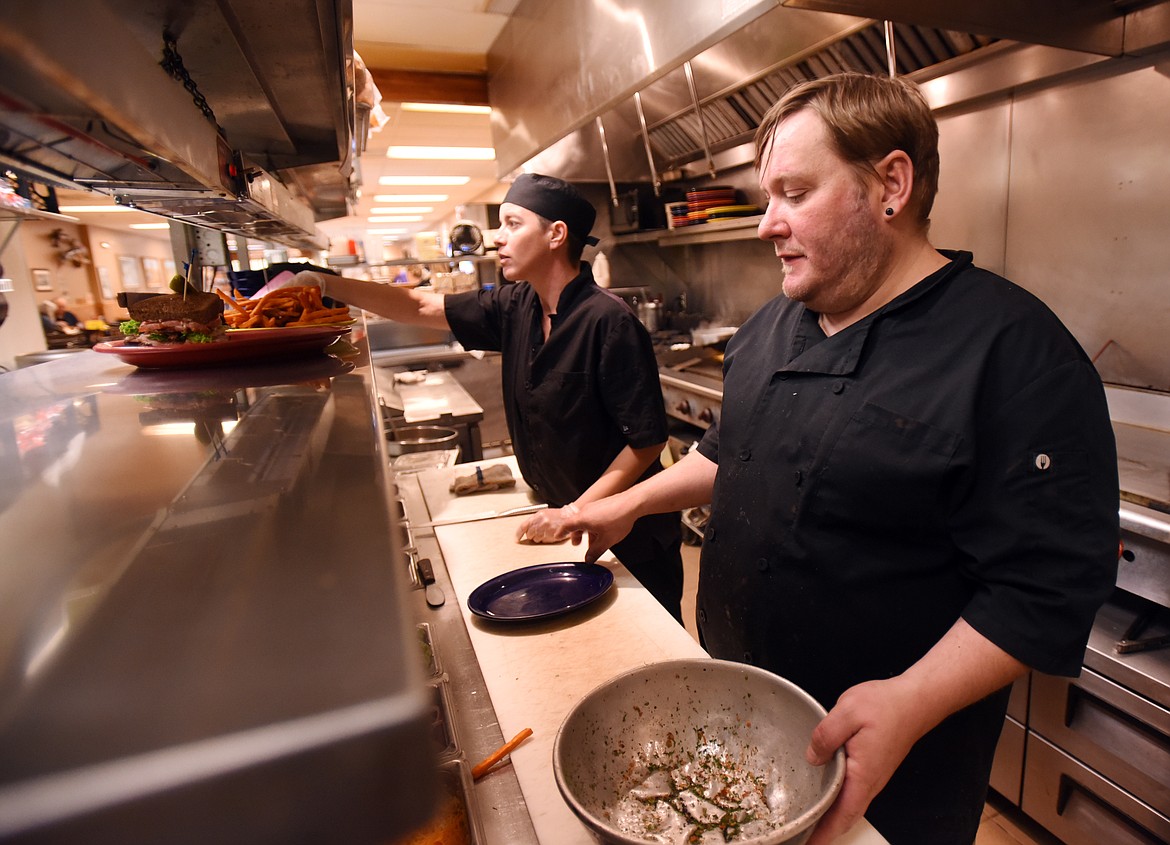 Josh Auerhammer and Sara Penneman, line cooks at Sykes in Kalispell, keep going even after the lunch rush has ended. The diner has reduced its hours to 7 a.m. to 3 p.m., but they are still open seven days a week. (Brenda Ahearn photos/Daily Inter Lake)