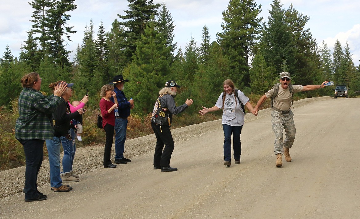 Photo by MANDI BATEMAN
Terry Brannon receives a hand shake from Ron McIlnay while being walked in by an enthusiastic retired Army Col. Dan Kern.