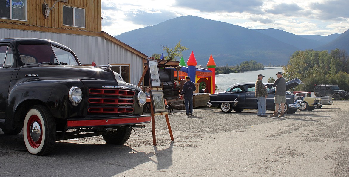 Spectators stop and talk with car show participants.