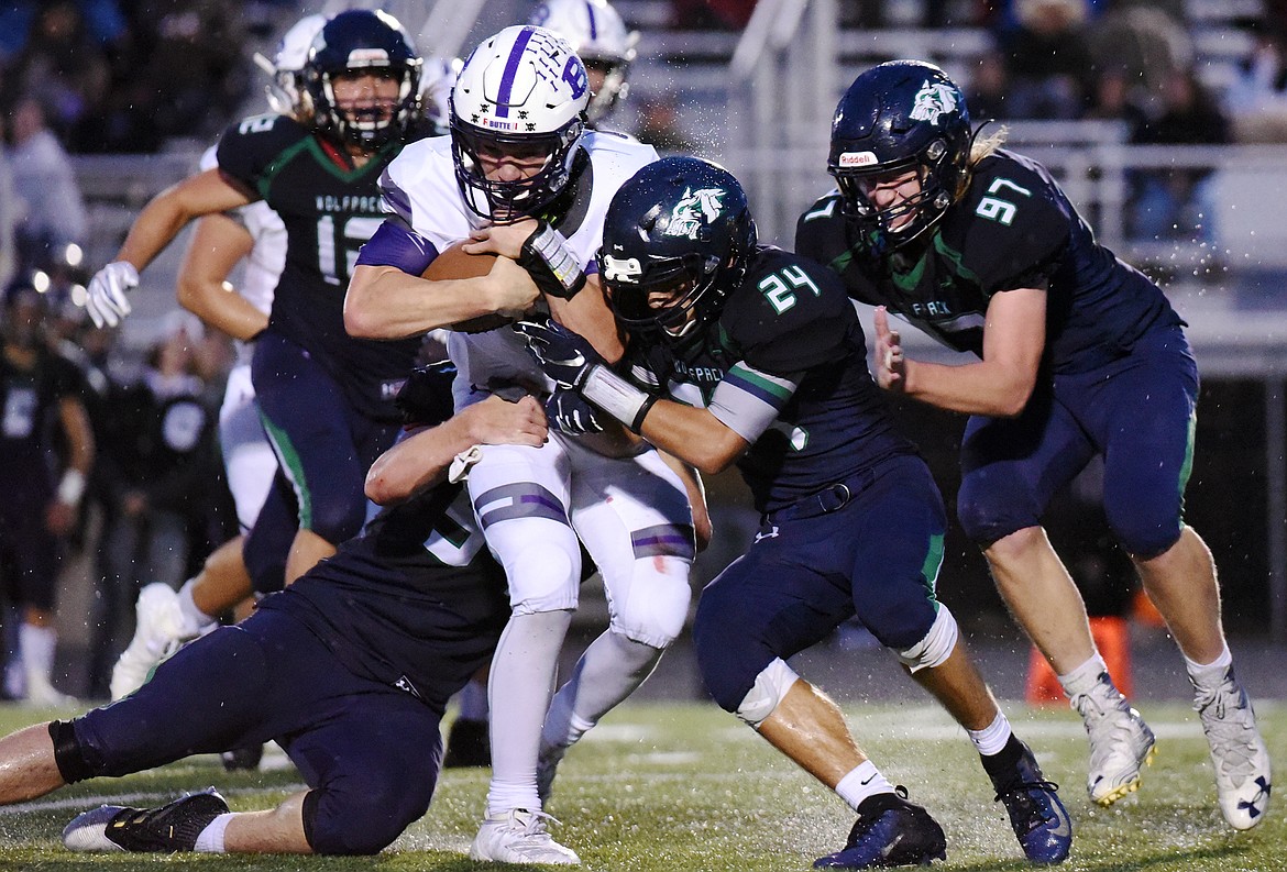 Butte quarterback Tommy Mellott (2) is wrapped up by Glacier defenders, from left, Henry Nuce (57), Caleb Morgan (24) and Thomas Cole (97) at Legends Stadium on Friday. (Casey Kreider/Daily Inter Lake)