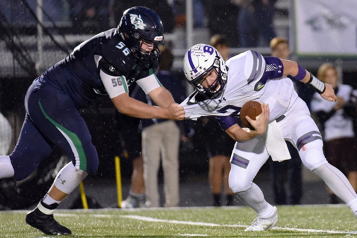Butte quarterback Tommy Mellott (2) breaks free from Glacier defensive lineman Rocco Beccari (56) in the backfield during the second quarter at Legends Stadium on Friday. (Casey Kreider/Daily Inter Lake)