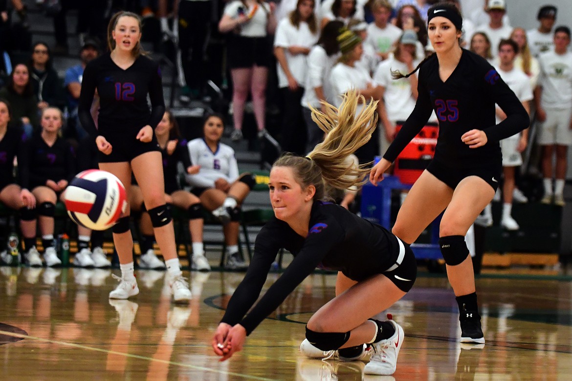 Dillen Hoerner makes a diving dig against Whitefish last week as Lauren Falkner (12) and Kiera Brown (25) look on. (Jeremy Weber photo)