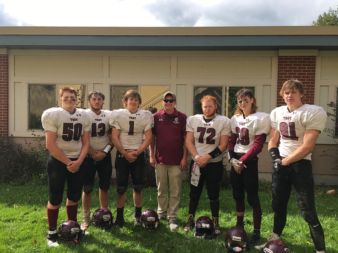 TROY HEAD coach Luke Haggerty, center, and his seniors got together for a photo after beating Victor, 42-6, Saturday. It was the Trojans' first win on the field since 2015. (Photo courtesy Luke Haggerty)