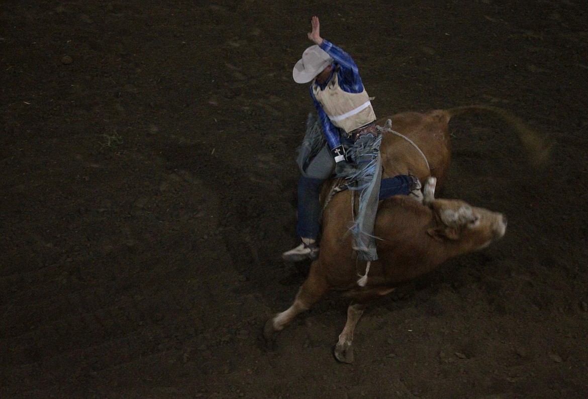 Casey McCarthy/ Columbia Basin Herald A cowboy is flung off during the bull-riding competition on Saturday night at the Othello Rodeo.