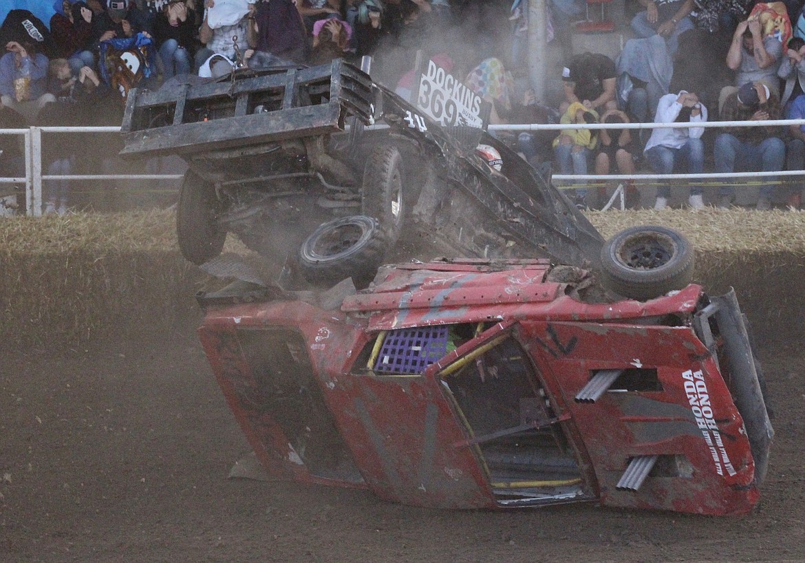 Casey McCarthy/ Columbia Basin Herald A pair of cars collide during a heat race near the finish, as #369 rolls over #71 at the Demolition Derby in Othello.