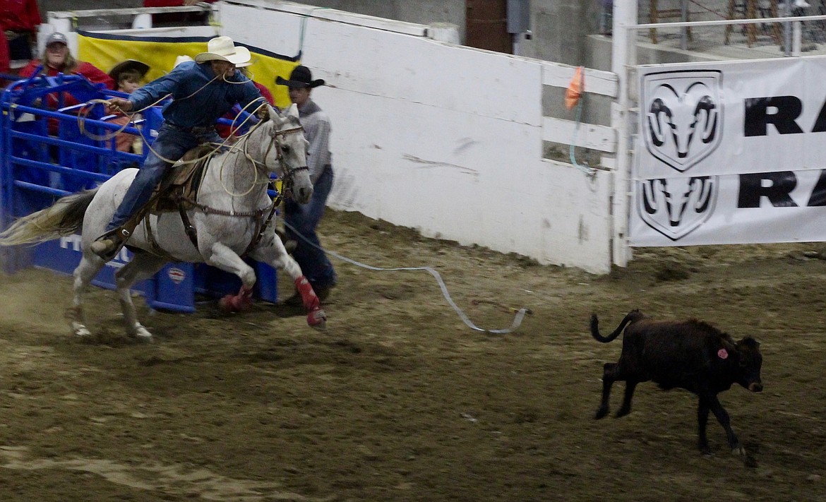 Casey McCarthy/ Columbia Basin Herald Preston Peterson chases down the steer in the tie-down roping event at the Othello Rodeo on Saturday night.