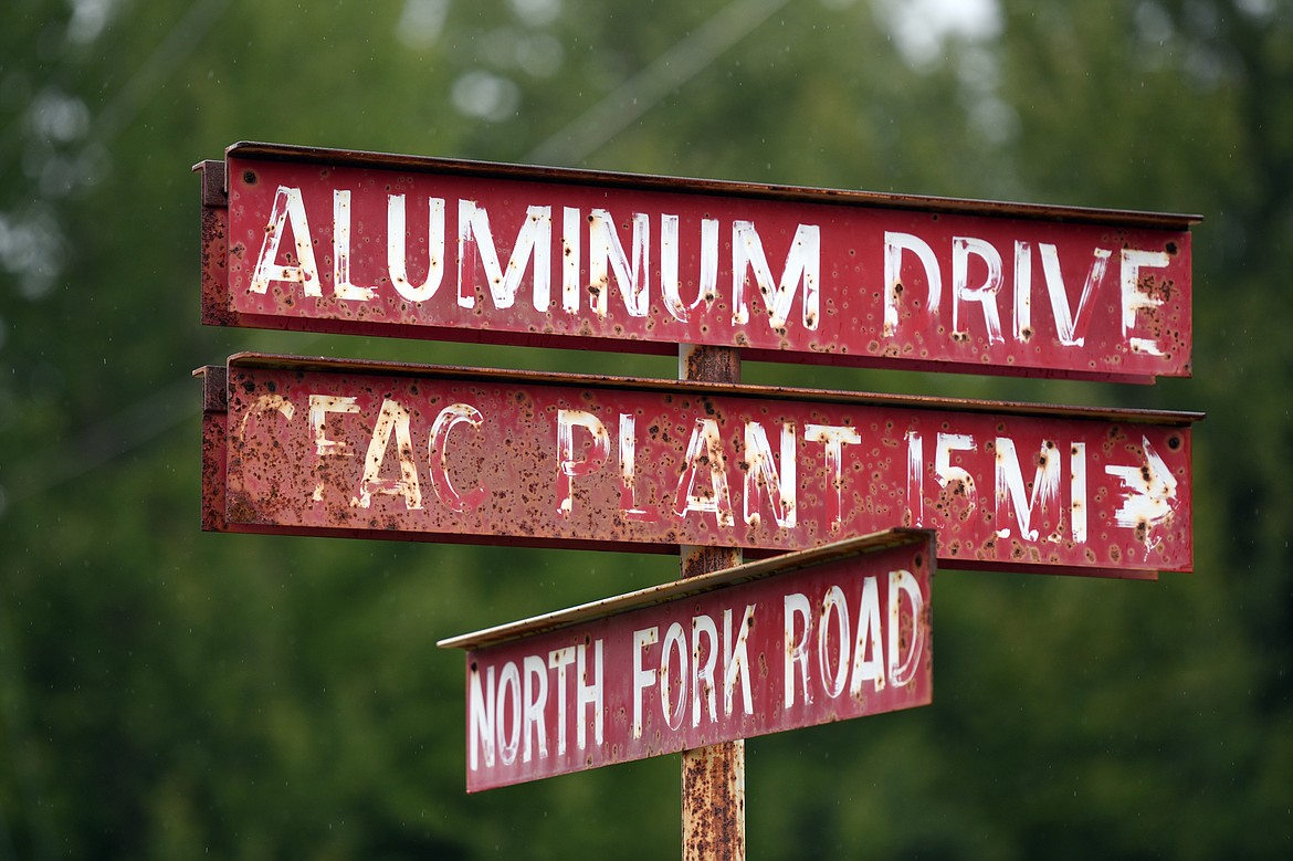 An old street sign indicating the intersection of the North Fork Road at Aluminum Drive near the Columbia Falls Aluminum Company property.