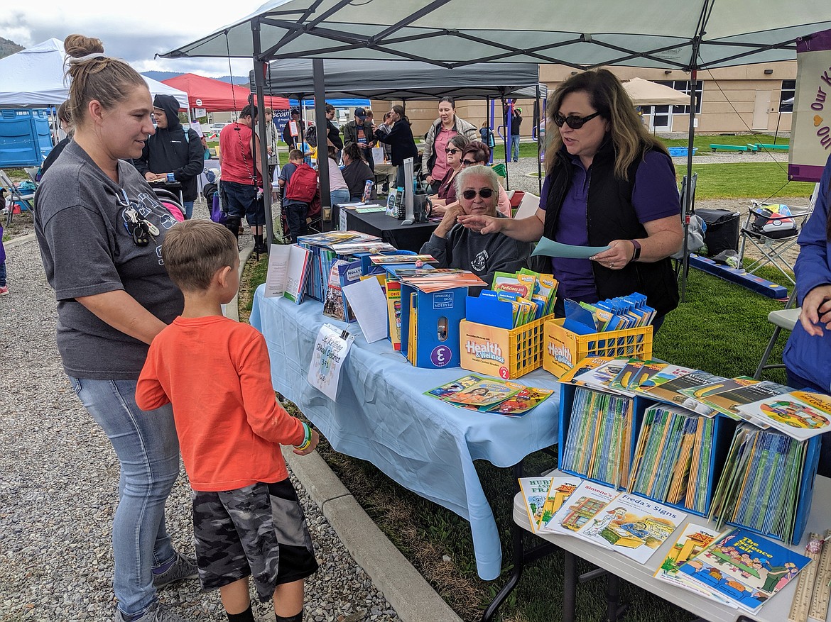 Kellogg School District Superintendent Dr. Nancy Larsen speaks with a parent and child at the Kellogg School District booth.