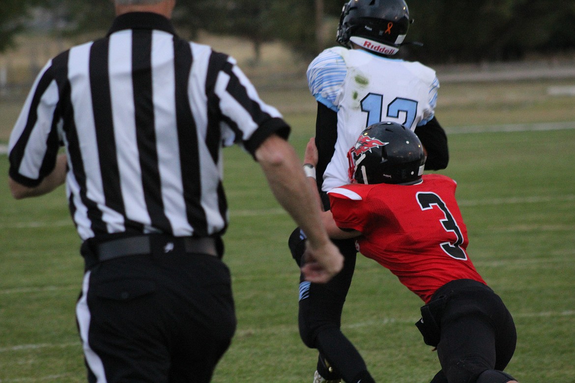 JACK MCALLISTER jumping several yards to make the tackle against Shields Valley's reciever. (John Dowd/ Clark Fork Valley Press)