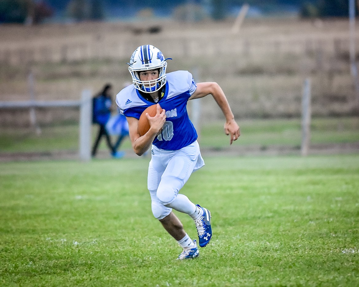 MISSION BULLDOG quarterback Isaac Dumontier picks up some yardage against Charlo Friday, Sept. 20. Dumontier was named the Homecoming King at halftime. (Photo courtesy of Christa Umphrey, Forward Photography)