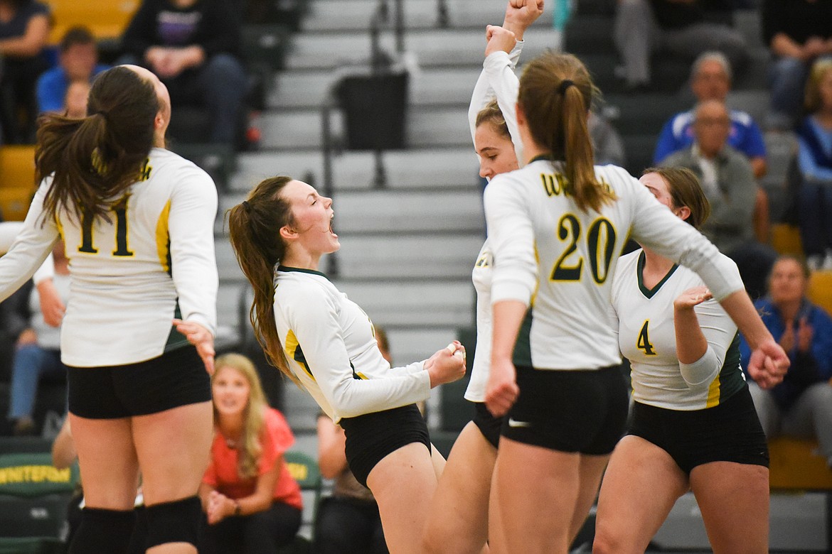 Kaiah Moore and her teammates celebrate a point against Columbia Falls last week. (Daniel McKay/Whitefish Pilot)