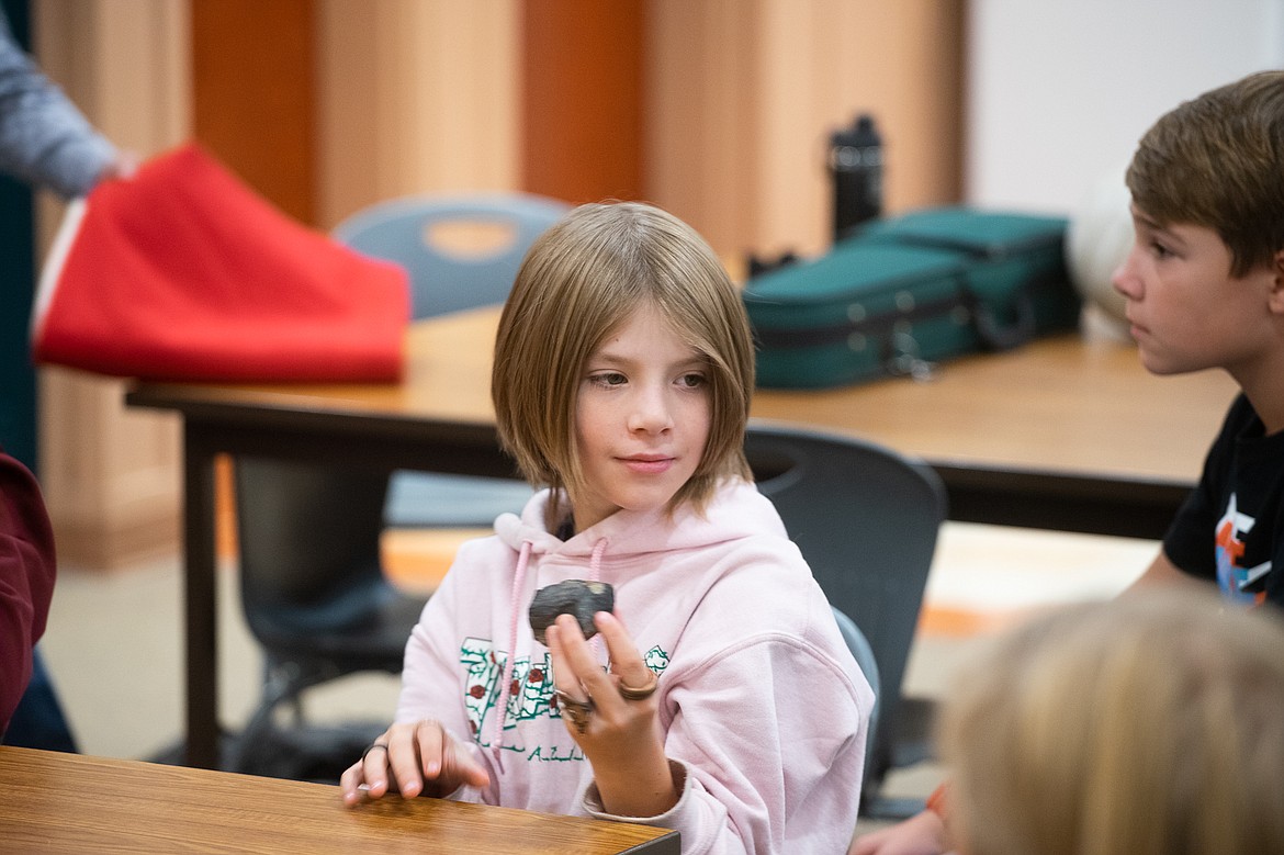 A student admires a Blackfeet artifact during a presentation by artist and elder Albertine Crow Shoe last week at Whitefish Middle School. (Daniel McKay/Whitefish Pilot)