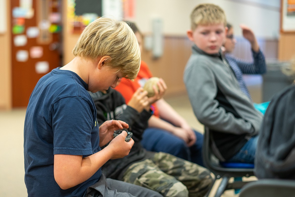 Owen Erickson admires a Blackfeet artifact during a presentation by artist and elder Albertine Crow Shoe last week at Whitefish Middle School. (Daniel McKay/Whitefish Pilot)