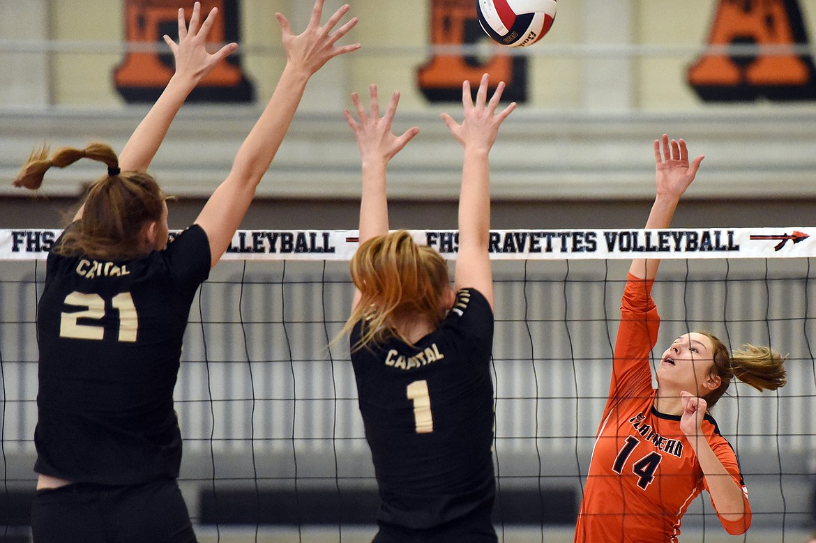 Flathead&#146;s Clare Converse (14) spikes against Helena Capital&#146;s Paige Bartsch (21) and Audrey Hofer (1) at Flathead High School on Saturday. (Casey Kreider/Daily Inter Lake)