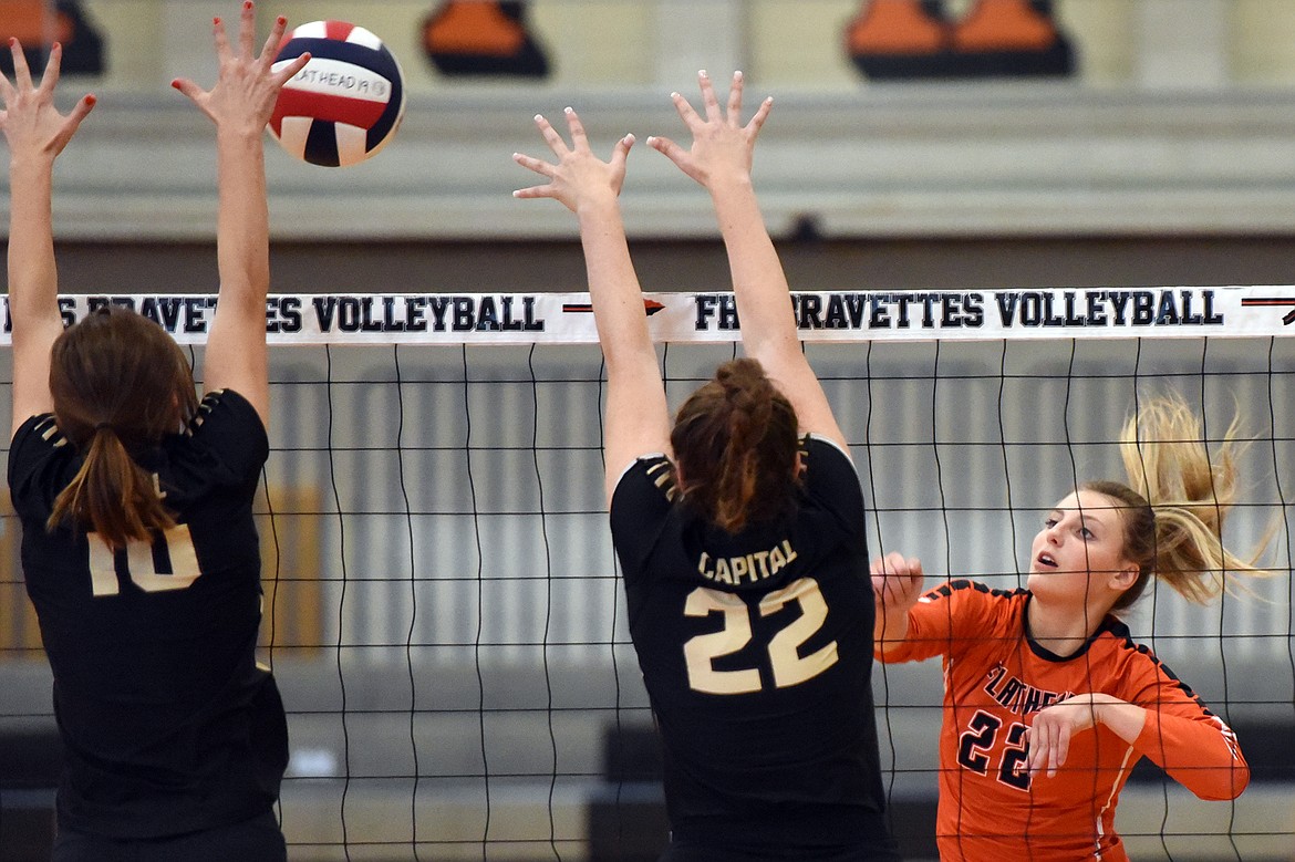 Flathead's Julia Burden (22) spikes against Helena Capital's Madison Davis (10) and MacKenzie Poteet (22) at Flathead High School on Saturday. (Casey Kreider/Daily Inter Lake)