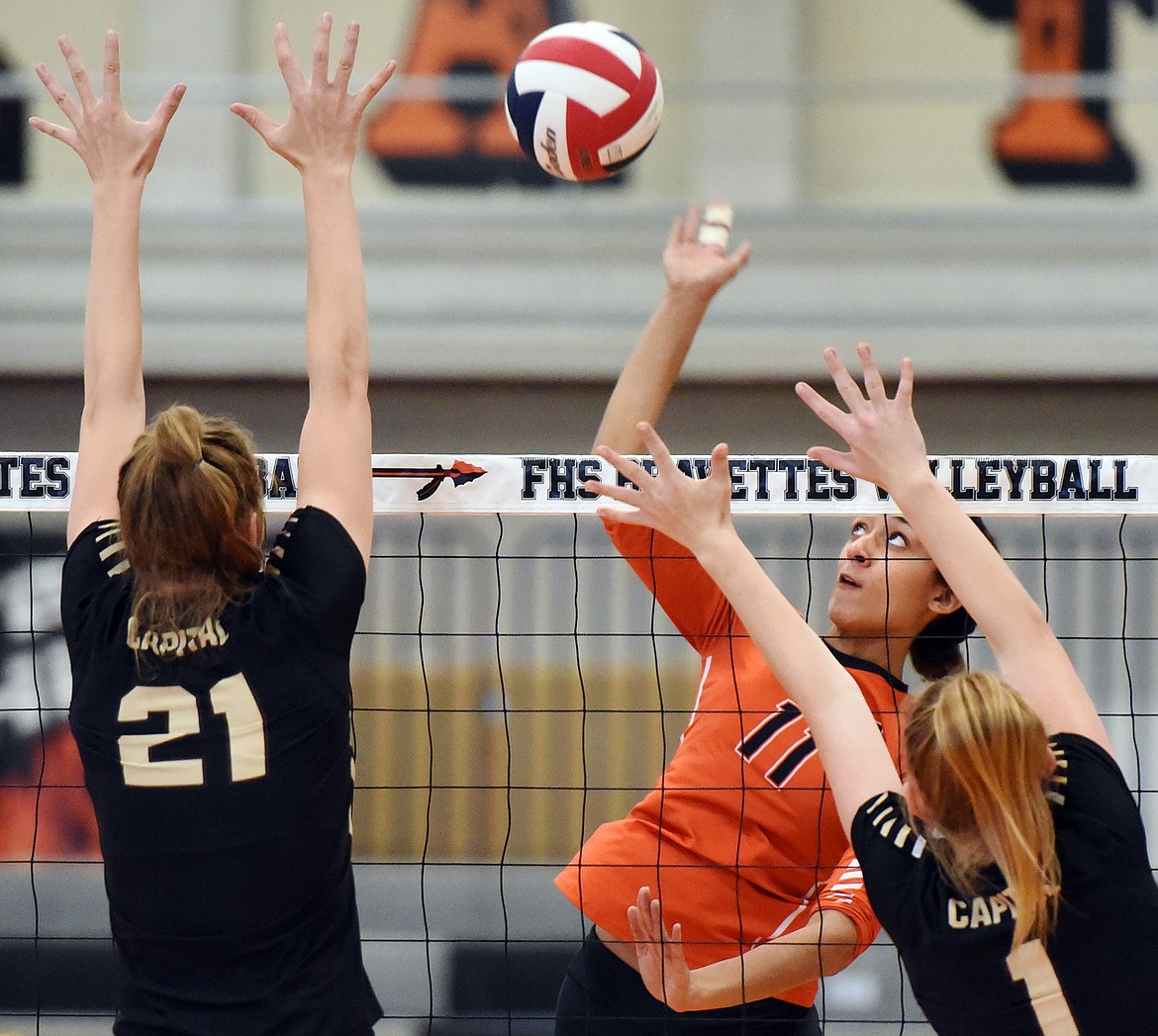 Flathead's Kaitlyn Kalenga (11) spikes against Helena Capital's Paige Bartsch (21) and Audrey Hofer (1) at Flathead High School on Saturday. (Casey Kreider/Daily Inter Lake)