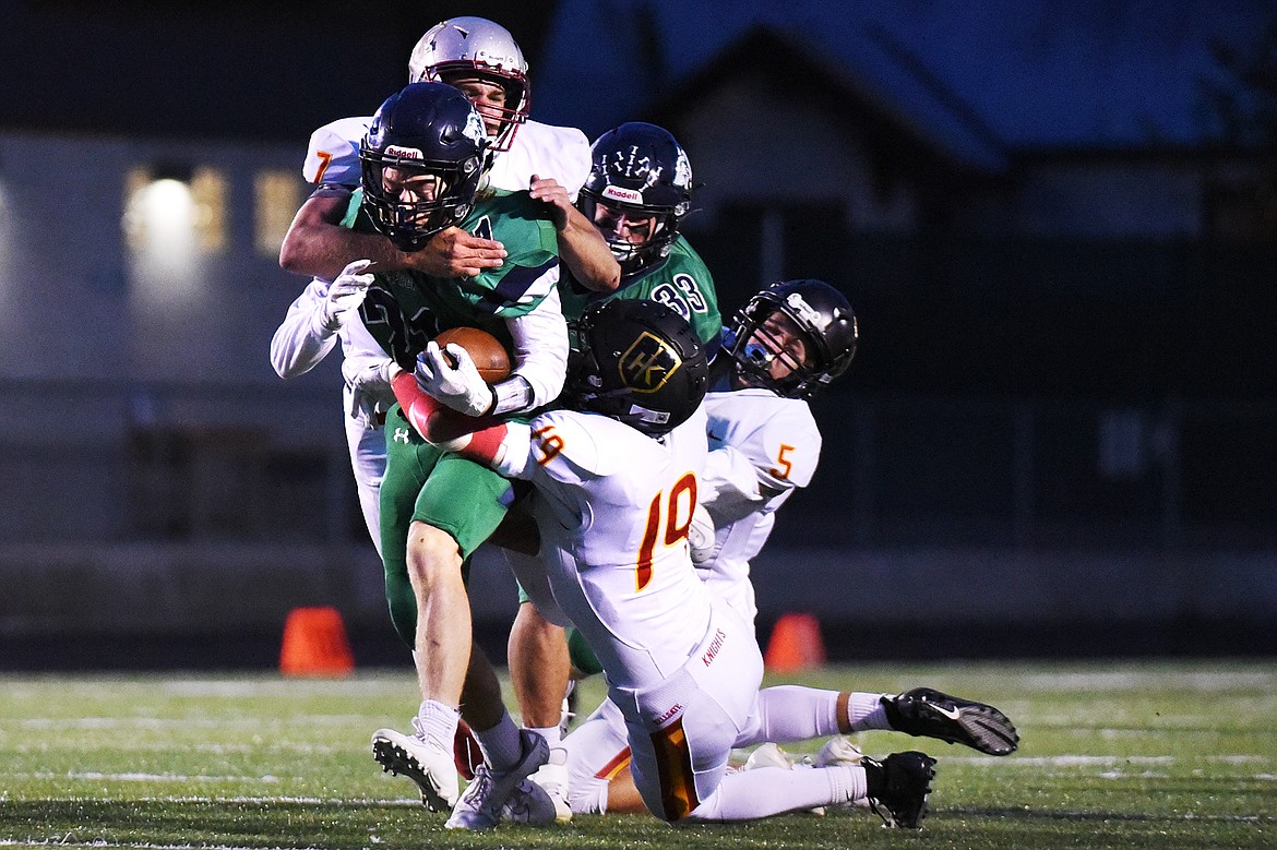 Glacier running back Casey Peiffer (21) is dragged down by Missoula Hellgate defenders on a first-quarter run at Legends Stadium on Friday. Glacier won, 35-28. (Casey Kreider/Daily Inter Lake)