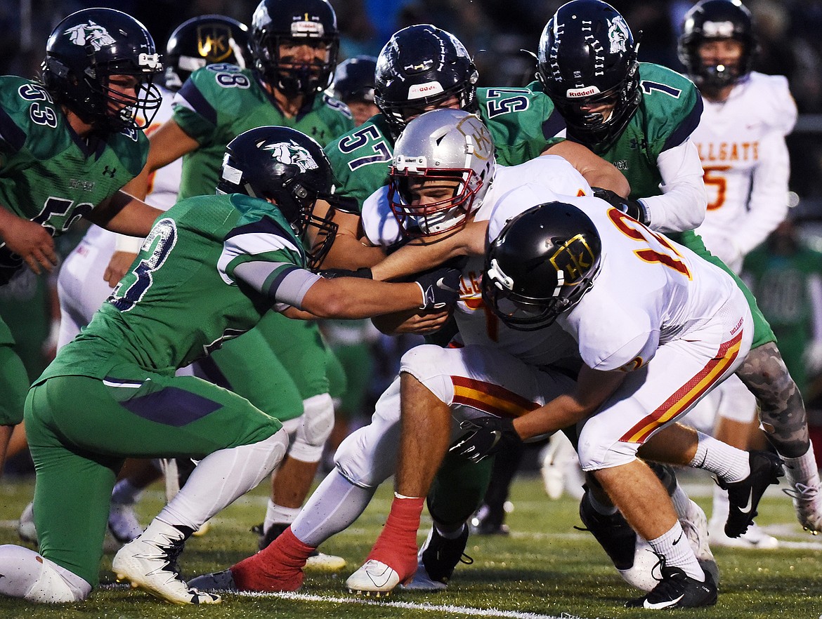 Glacier defenders, from left, Justin Olson (53), KJ Johnson (43), George Herne (88), Henry Nuce (57) and Colin Bowden (1) stop Missoula Hellgate quarterback Rollie Worster (7) on a first-quarter run at Legends Stadium on Friday. (Casey Kreider/Daily Inter Lake)