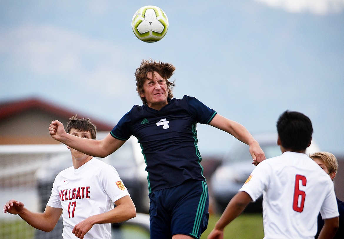 Glacier's Braden Nitschelm (4) heads the ball in between Missoula Hellgate defenders at Glacier High School on Thursday. (Casey Kreider/Daily Inter Lake)