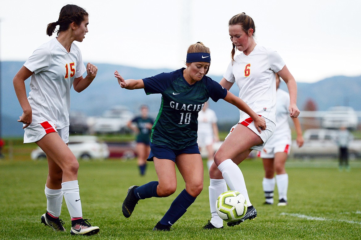 Glacier's Madison Becker (18) works the ball past Missoula Hellgate's Gabriella Beaton (15) and Clara Tallent (6) at Glacier High School on Thursday. (Casey Kreider/Daily Inter Lake)