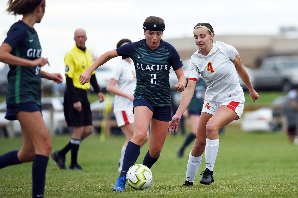 Glacier's Emily Cleveland (2) pushes the ball upfield against Missoula Hellgate's Elaina Pierce (4) at Glacier High School on Thursday. (Casey Kreider/Daily Inter Lake)