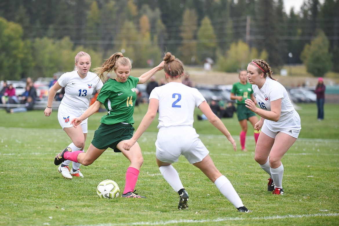 Whitefish's Josie Schneider takes on a trio of Bigfork defenders during a home match at Smith Fields. (Daniel McKay/Whitefish Pilot)