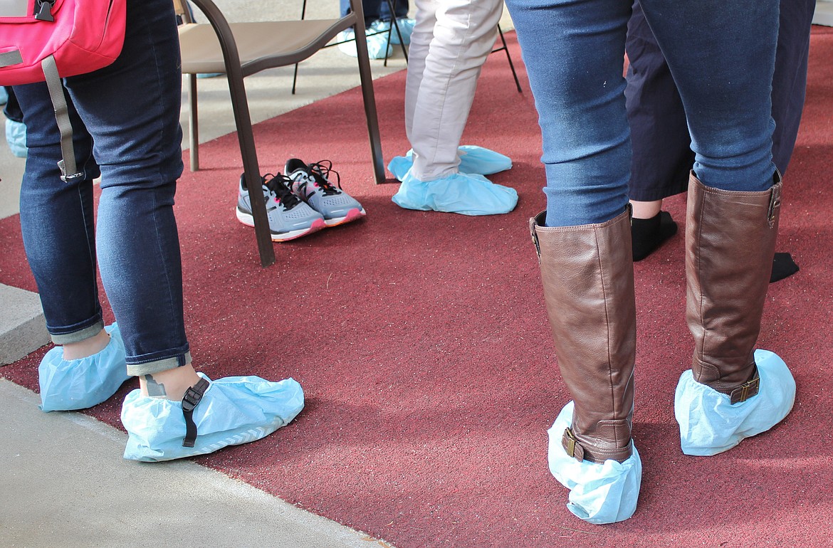 Courtesy photo
Tourists attending the home tour portion of Wallace&#146;s Fall for History Festival put protective coverings over their shoes as they tour the historic homes of residential Wallace.