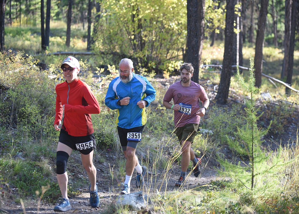 Julie Lacey, John Lacey and Charles Katerba make their way up the Whitefish Trail near the start of the half marathon Sunday during the Whitefish Trail Legacy Run. (Heidi Desch/Whitefish Pilot)