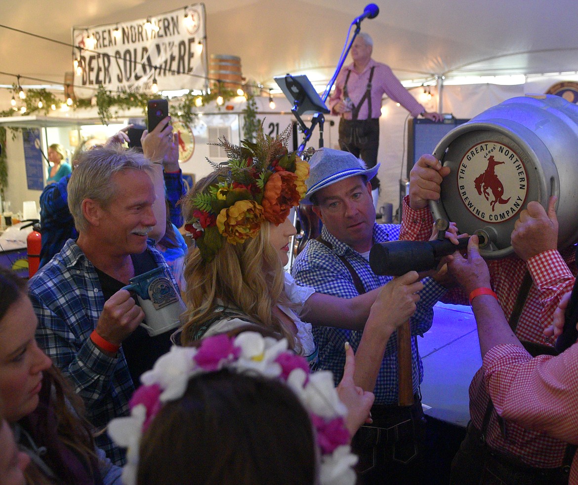 Hop Queen Kate Houlihan taps the first keg for the 2019 Great Northwest Oktoberfest Thursday night. The festival continues Oct. 3-5 at Smith Fields. (Heidi Desch/Whitefish Pilot)